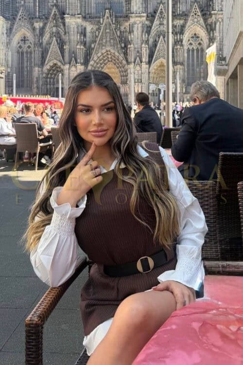 London escort relaxing at outdoor cafe near cathedral.