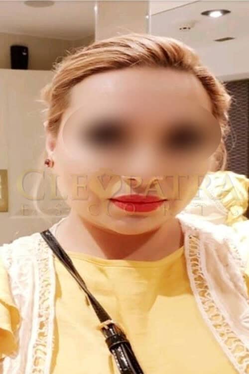 Escort with blonde hair and red lipstick in London.